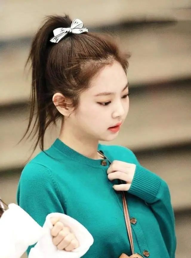 jennie的高马尾就更俏皮一些,尤其是还搭了一只小蝴蝶结,配上亮色针织