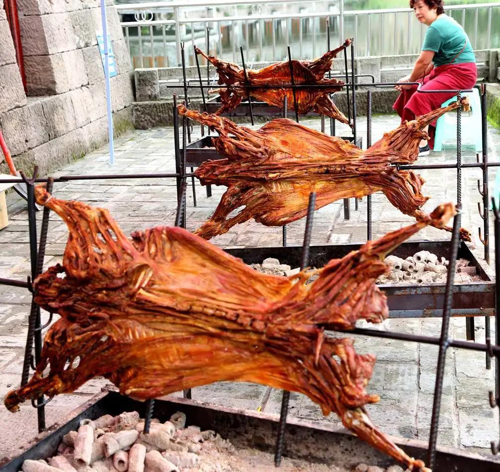 在四娃子山庄,一溜排着四五个烤羊架,架上羊肉金黄,盆中木炭正红,看到