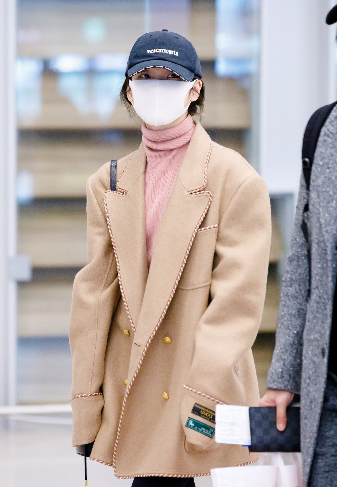 身着卡其色外套搭配粉色高领毛衣的iu真的是可爱极了