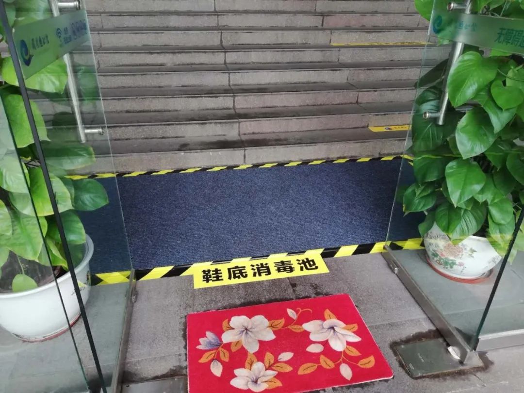 门口已经放好了进馆请戴口罩,配合检测体温等提示标志,地上放置了消毒