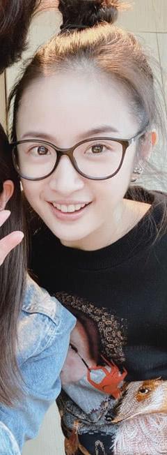 林依晨穿着印花黑色卫衣,头发高高的扎了一个丸子头,带着黑框眼镜露出