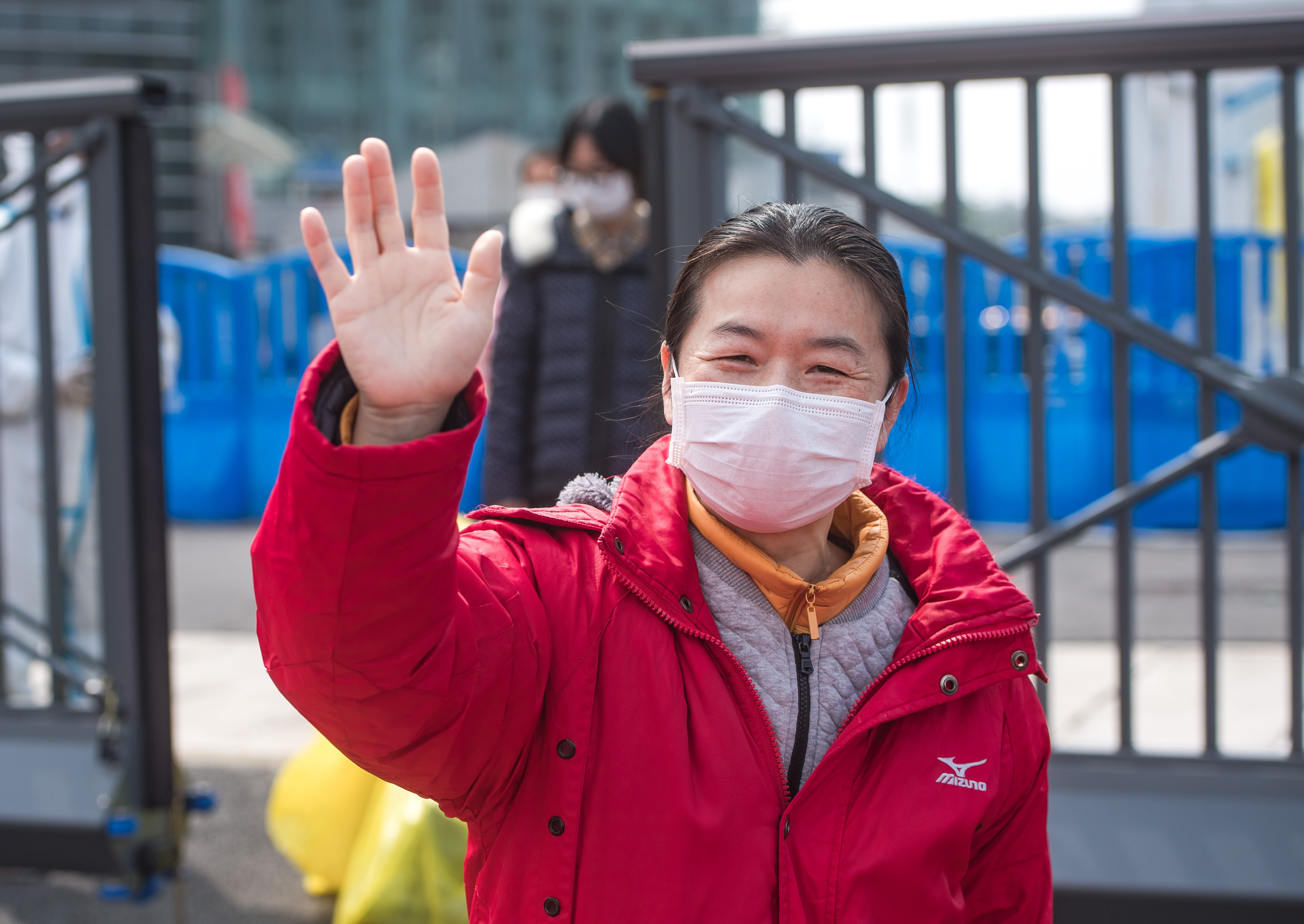 3月8日,一名痊癒患者與貴州醫療隊員揮手告別.