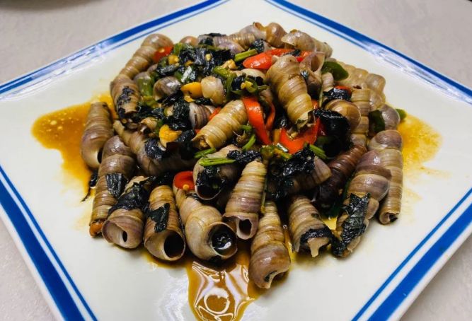 紫苏炒钉螺也非常美味,只需要轻轻吸一口,钉螺肉跐溜就钻进嘴里,伴随