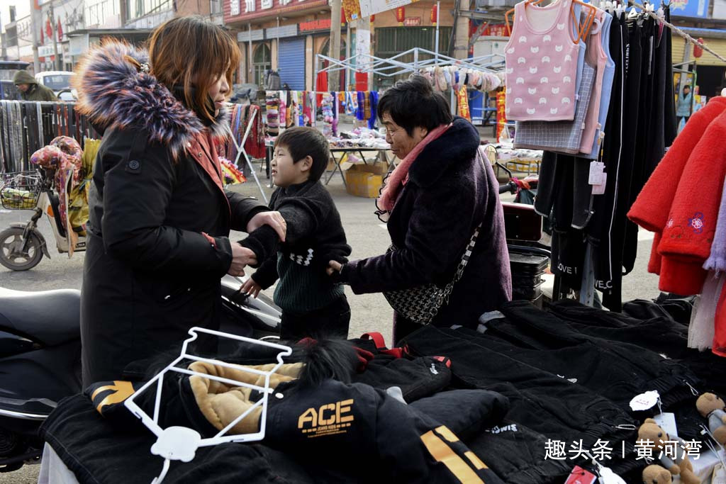 山西农村腊月集市年味浓浓在外打工的父母回乡给孩子买新衣服