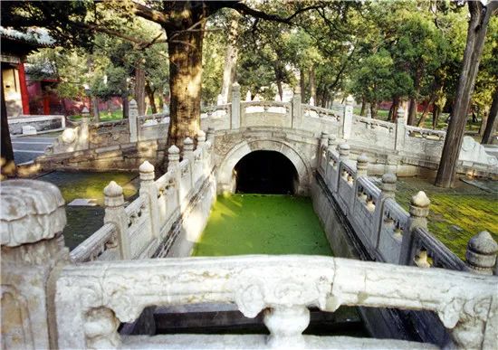 庭院内,古木参天,芳草如茵,东西对称各有一腰门,对面三架拱桥掩跨璧水