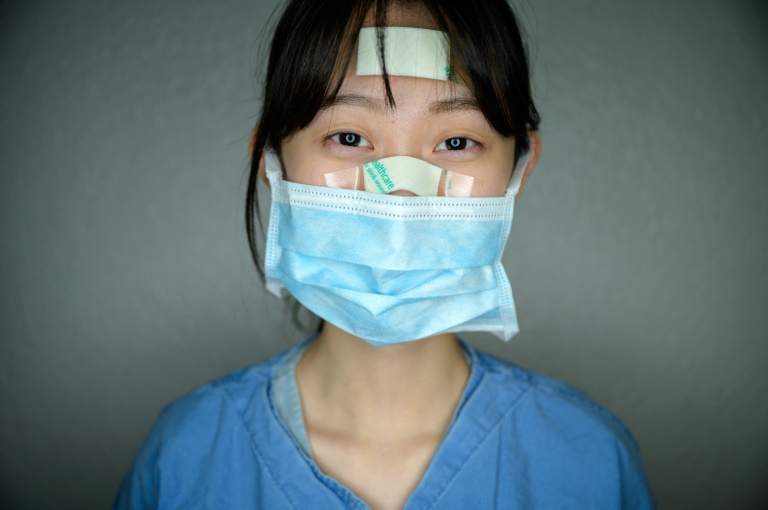 这些护士的脸上都贴上了胶布,绷带和护垫,可以保护脸部免受损伤,因为