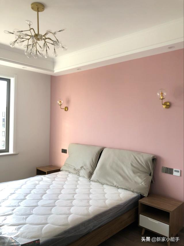 这是次卧,床头墙面刷了粉色乳胶漆,装饰感很强,可以看得出来,女屋主有