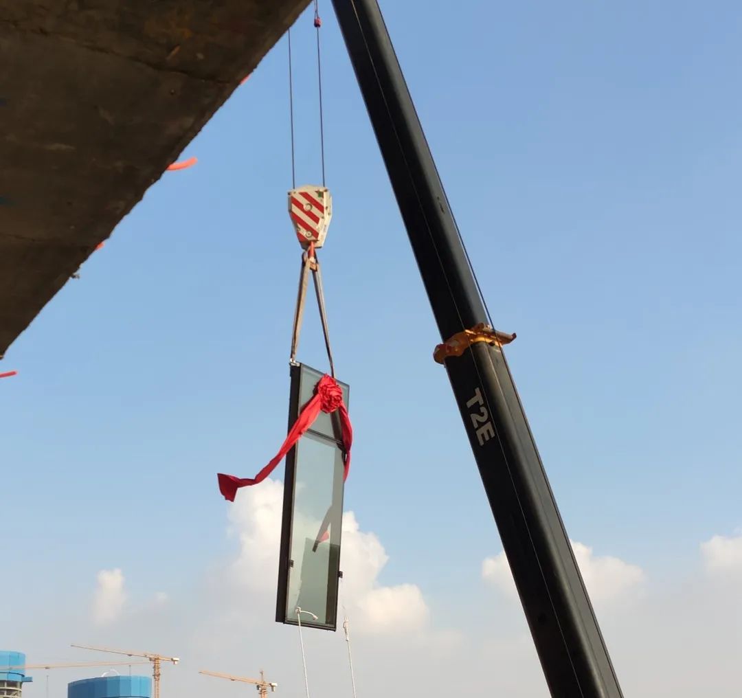 首块幕墙单元体在塔吊牵引下缓缓上升,平稳安装至楼层预定位置,标志着