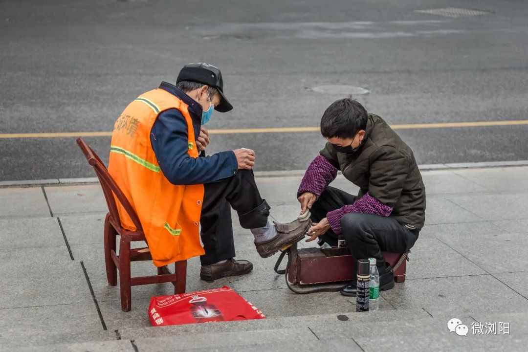 在新浪微博@看见 推出一张,浏阳街头擦鞋人给环卫工人擦皮鞋的照片后
