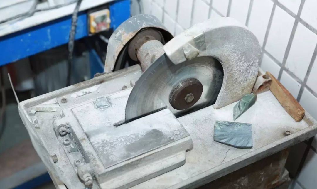 用来切割毛料的切割機雕刻師傅正在打燈研究,观察原石情况正式切割对