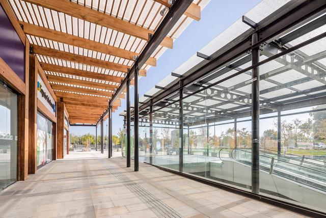 超市外侧走廊上水平木梁与垂直钢柱,以及商店的橡木饰面,与项目所处的