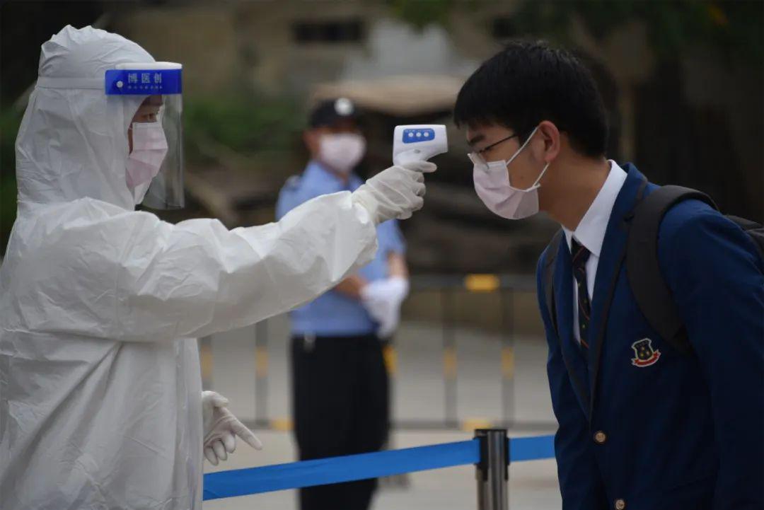 学生佩戴口罩,携带健康卡,保持安全间隔,有序排队入校.