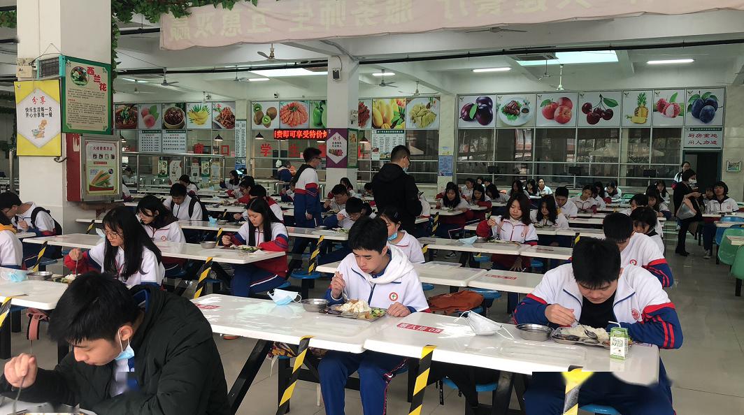 午间,高三学生按间隔距离在食堂吃午餐.
