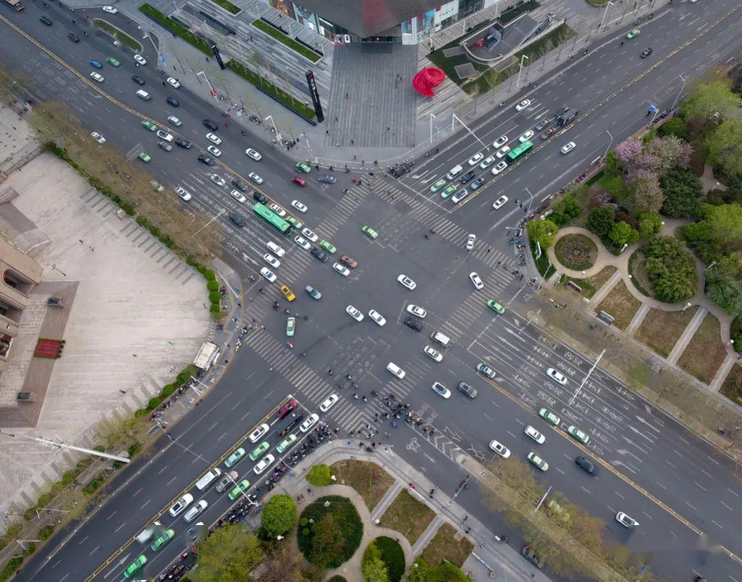 不同方向驶来的车流,奔走的人流,在交叉路口相遇,并井然有序地相隔出