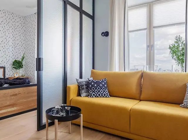 客厅的沙发靠着窗边,搭配一个可爱的小圆几,明黄色的沙发是整个客厅最