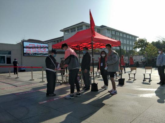 池州市第六中学采用红外测温仪为报到学生测量体温.