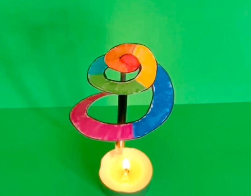 蜡烛被点燃后,火苗上方的螺旋状的纸片开始绕着笔芯持续旋转起来