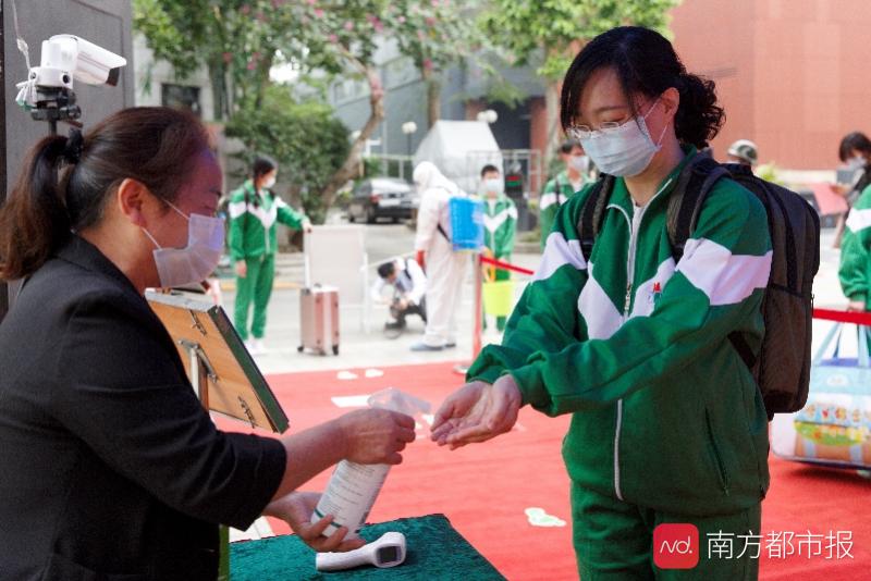 越秀区育才实验学校,工作人员对入校学生进行体温测量.