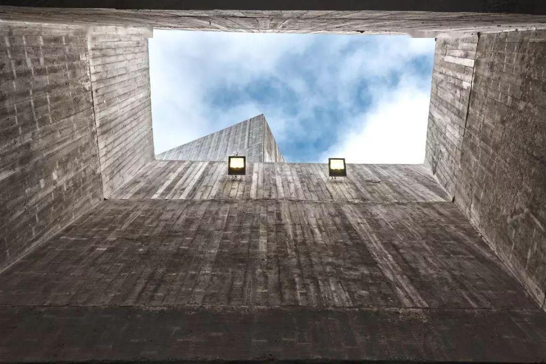 混凝土天井的矩形开口与玻璃墙的边界扭转嵌套在一起,于自然质朴中