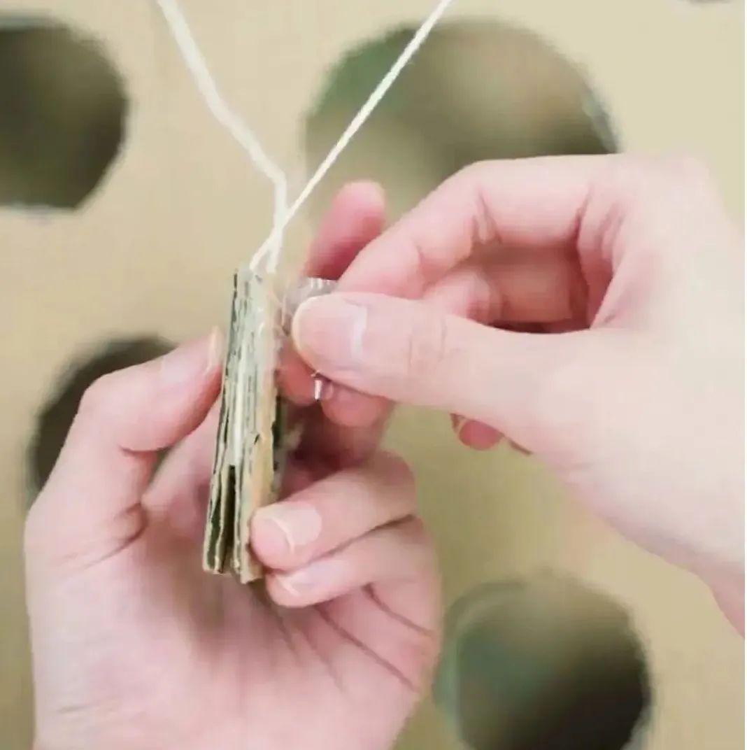 将弹珠放在卡片中间的镂空里,拉动绳子,控制卡片走向,注意不要掉到