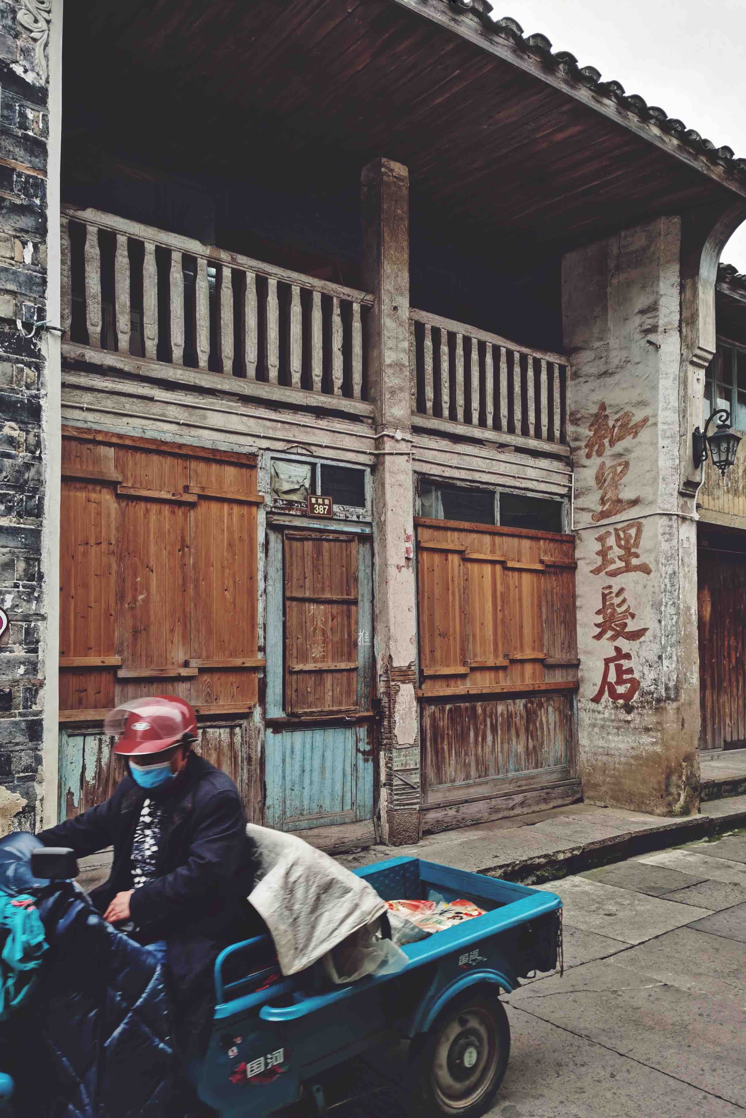 紫阳街上的老式理发店一位老人骑着三路车穿行在古街巷紫阳街游人最多