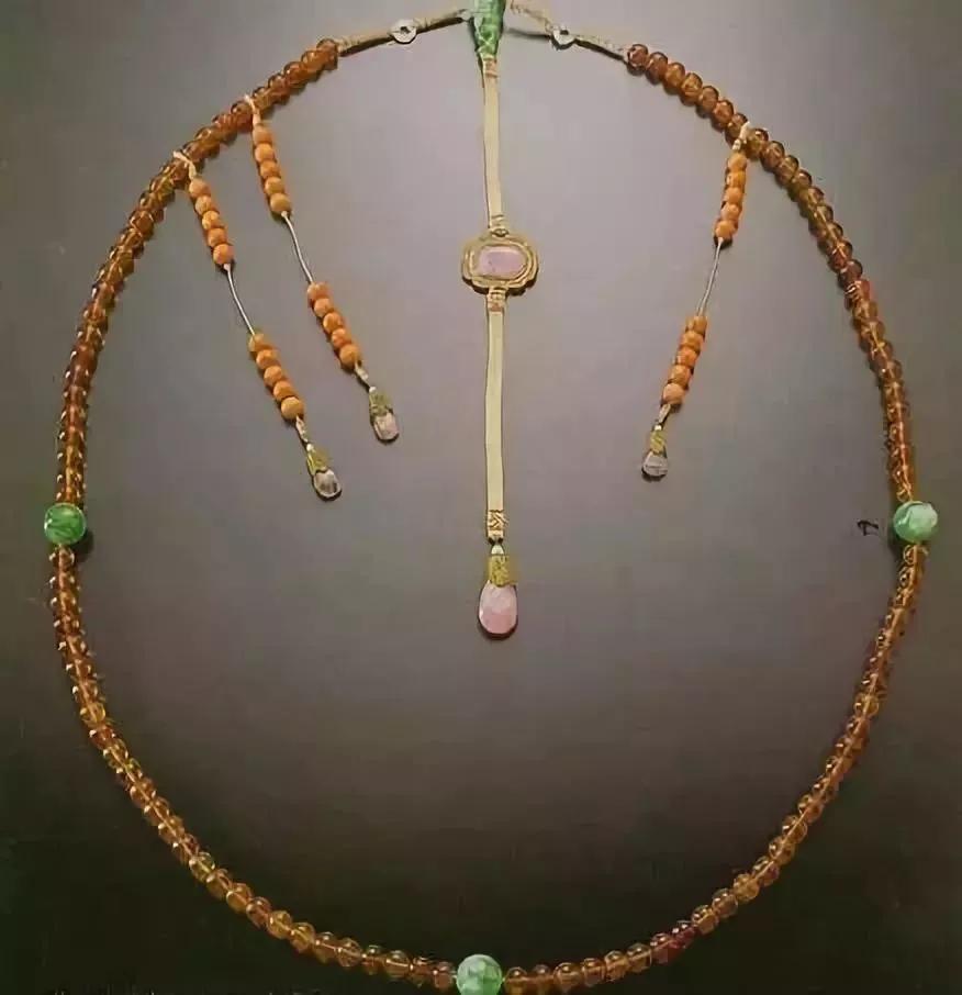 皇后,皇太后穿朝服时戴一盘东珠外,还在两肩斜挂两盘红珊瑚朝珠,以示