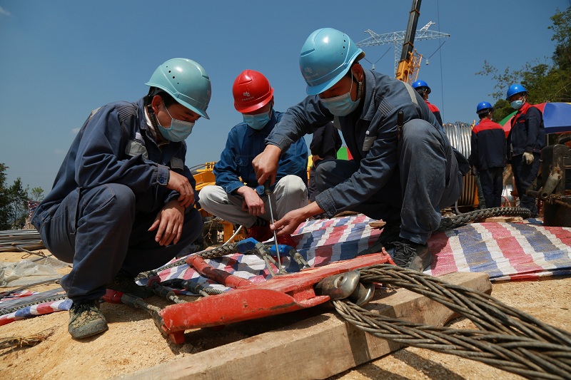 施工作业人员在紧固走板转向接与拖带导线猪笼套的螺丝.