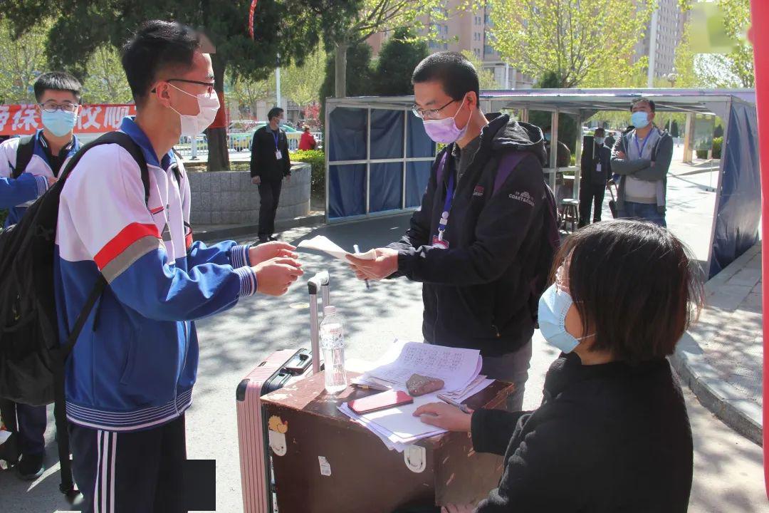 在执勤老师引导下,孙浩森和其他同学排成一队,测量体温,登记信息