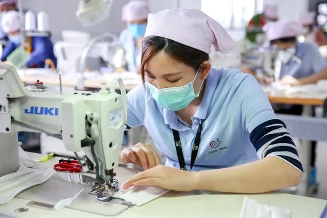 广东溢达制衣厂梭织车缝车间,300多台半自动缝纫机排成几条长龙,工人