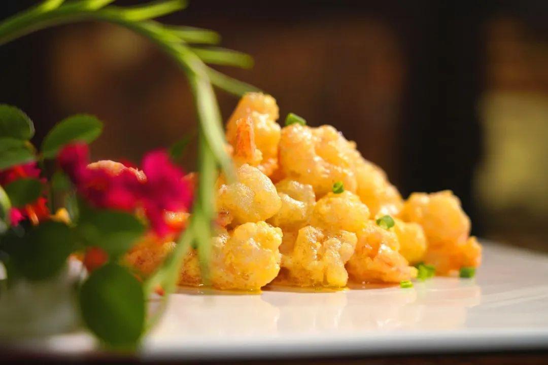 咸蛋黄焗汉虾锅底铺上准备好的葱段,芹菜,放入解冻好的汉虾,将调制好