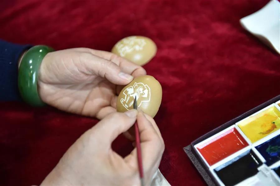 赵伟在蛋壳上雕刻猴子图案
