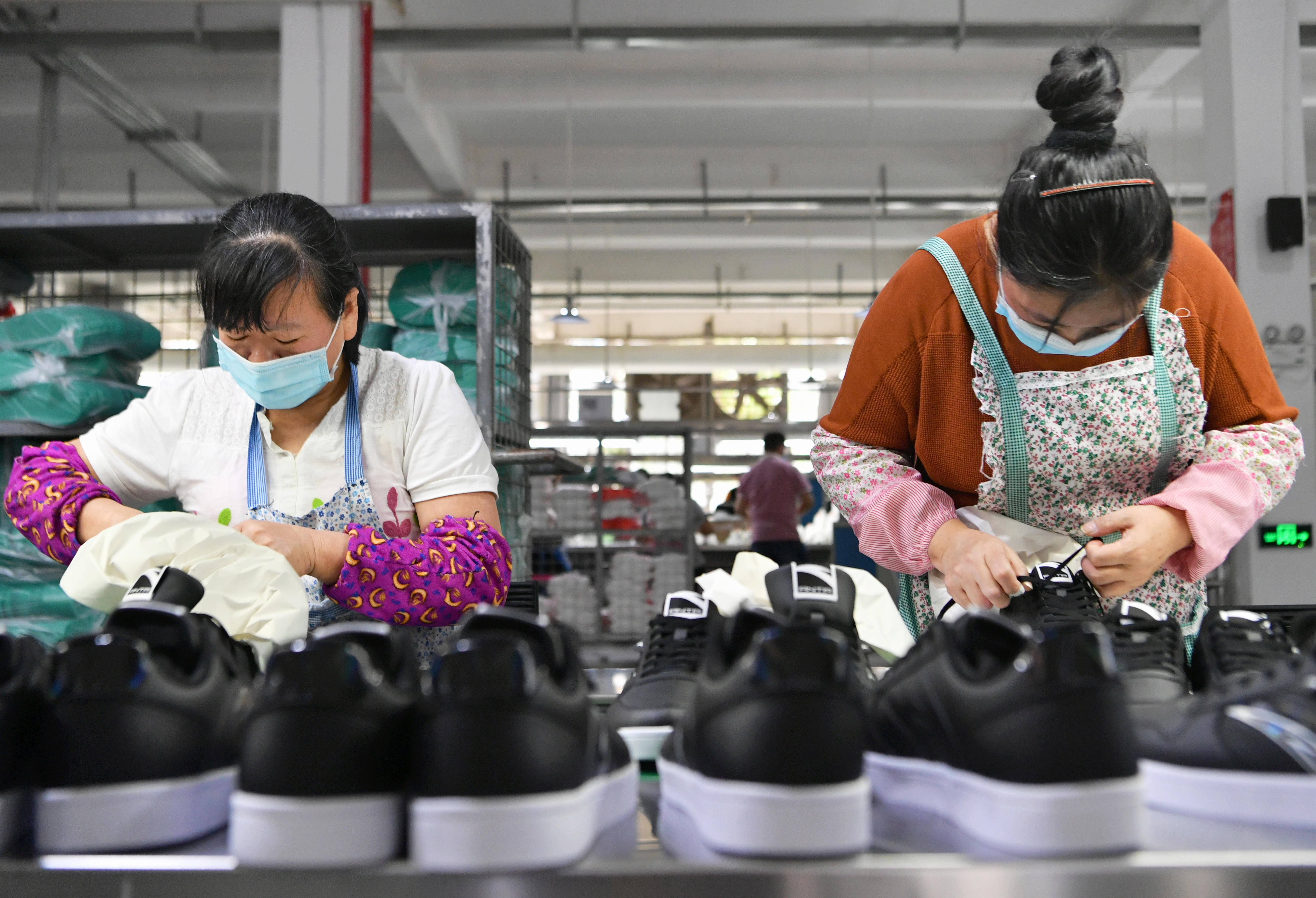4月27日,在莆田市城厢区的一家鞋企生产线上,工人们在抓紧生产