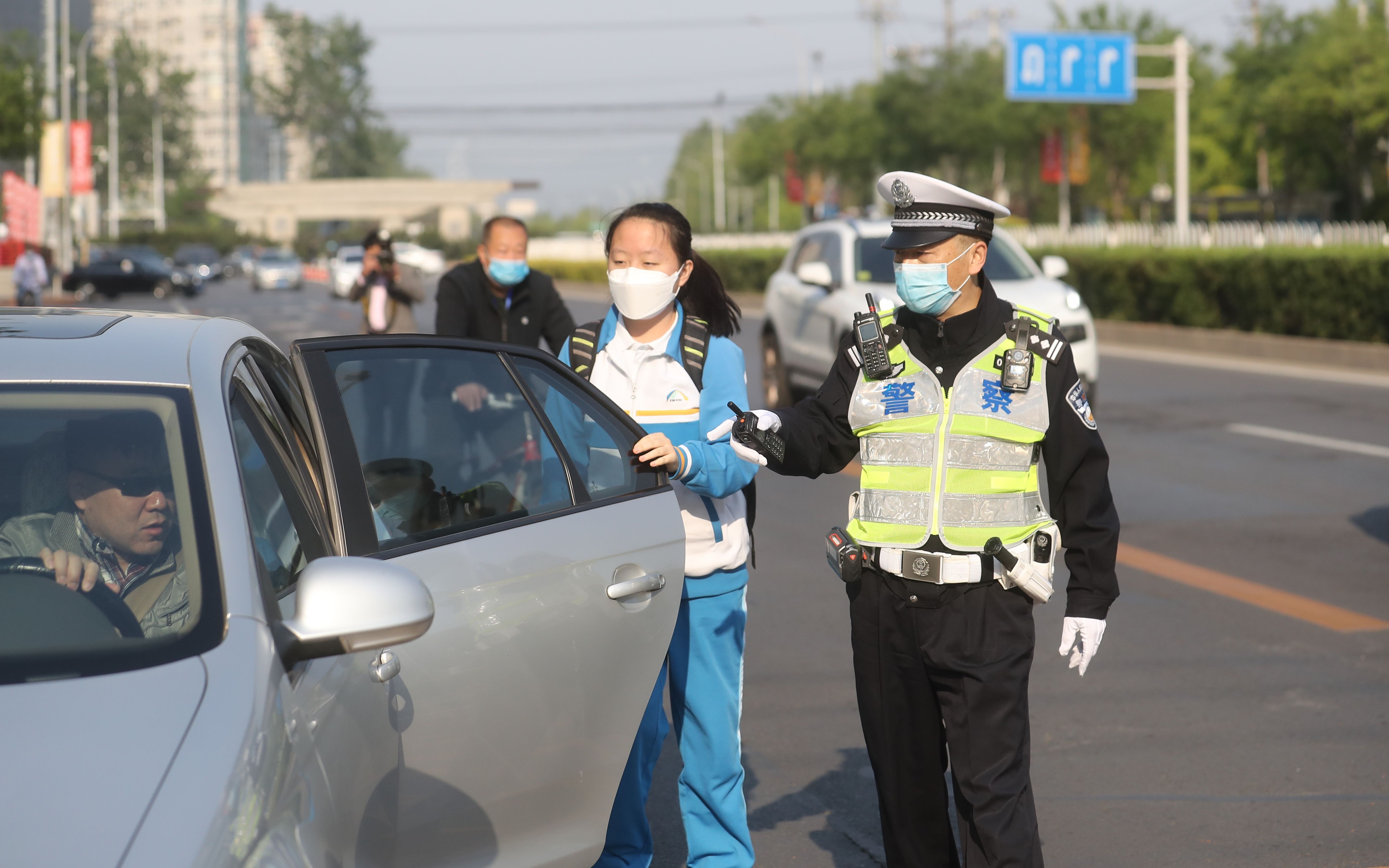 北京高三今起复课,交警校门前疏导交通,车辆即停即走