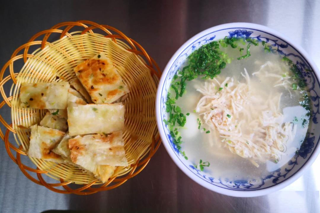 在炖煮数个小时的母鸡汤里下一把汤粉,再配上香香脆脆的葱花饼,让鸡汤