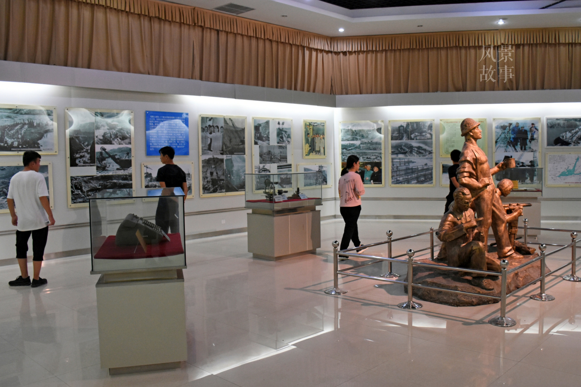 游客三三两两在里边停留观看.展览馆内的三门峡水利枢纽沙盘.