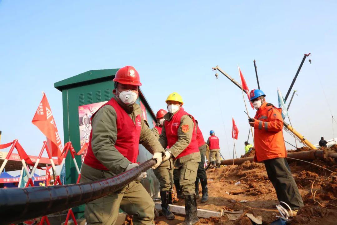 建筑工人穿着防护服在雷神山里调试设备.