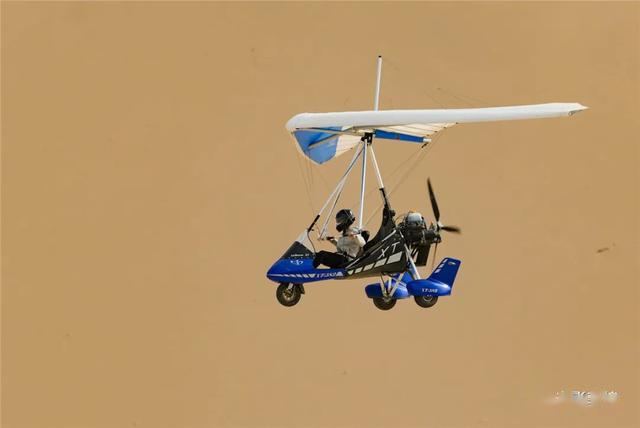 五一敦煌直升机滑翔机在鸣沙山月牙泉上空自由飞翔