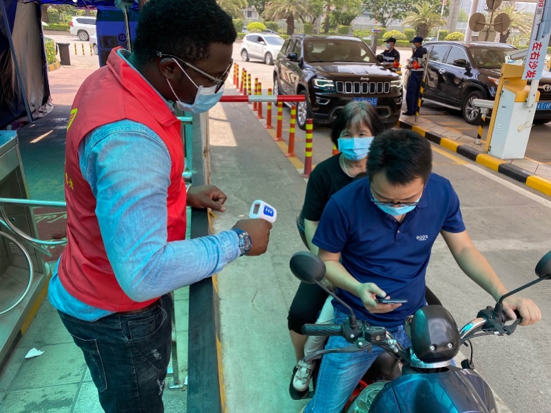 戴口罩测体温广州这条街的中外青年志愿者携手战疫