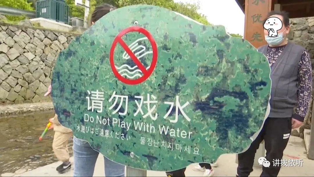 火车广场附近的溪边,虽然景区设置了"请勿戏水"的标志牌,但游客似乎视