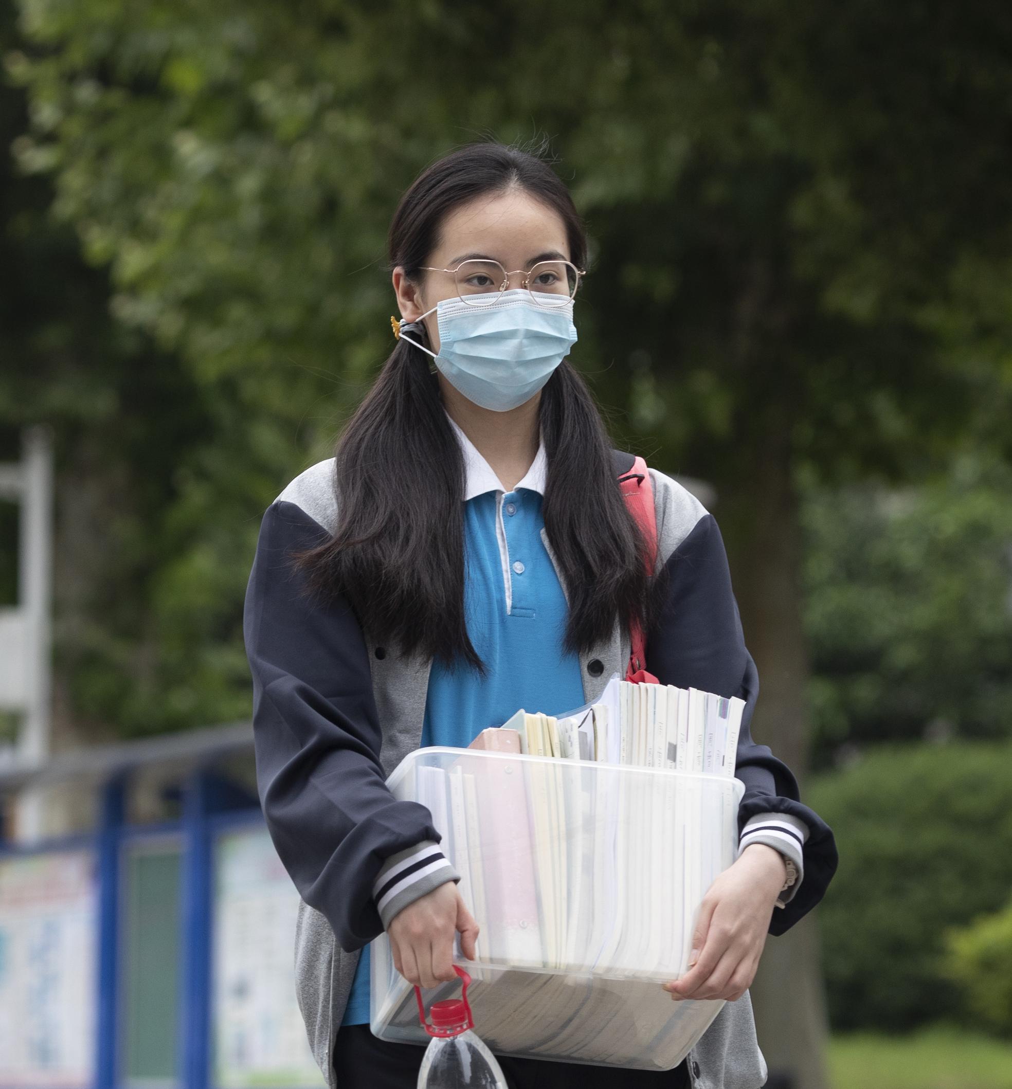 湖北省武汉市第十七中学的高三学生带着书本进入校园