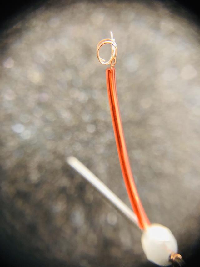 把细铜丝穿过针灸针的环柄中对折下面开