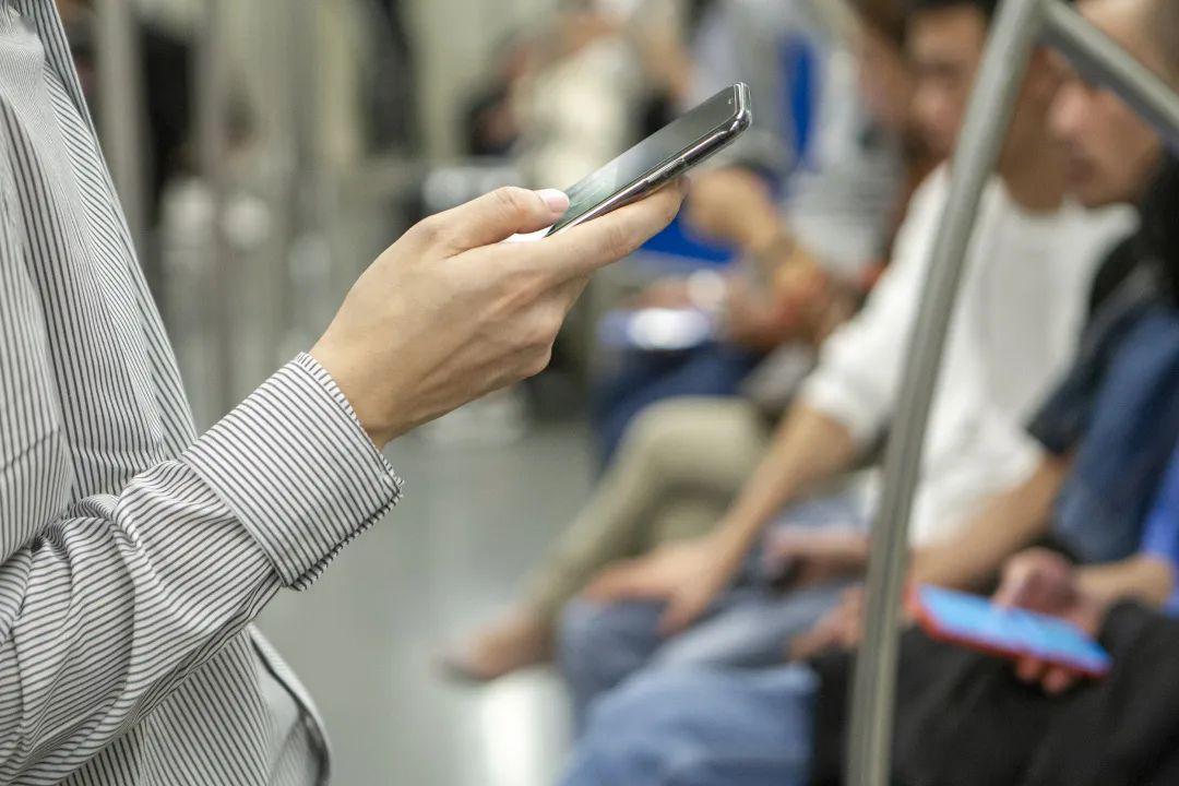 2019年10月11日,上海,地铁上,一位白领正在上班途中刷手机