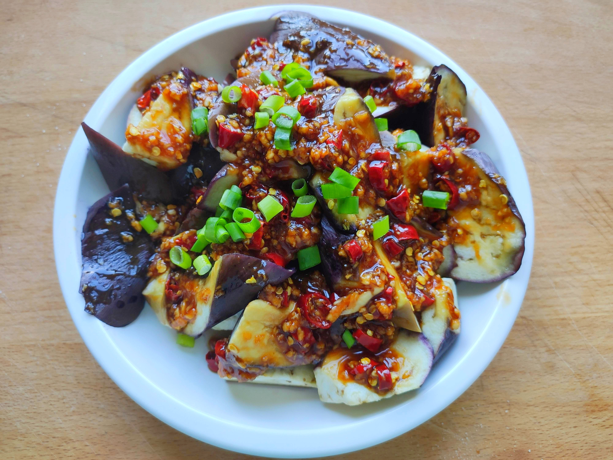 把油加热至微微有一点冒烟,均匀浇在料汁上,蒜香蒸茄子就做好了