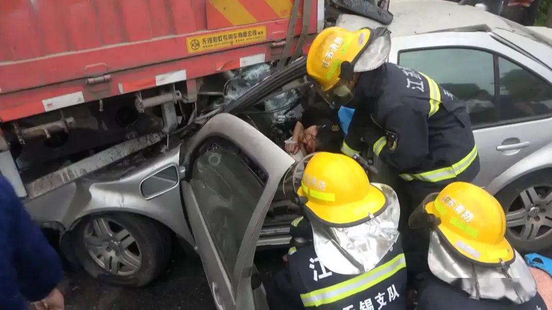 无锡一小轿车"咻"地钻到了大卡车底部.驾驶员被卡!