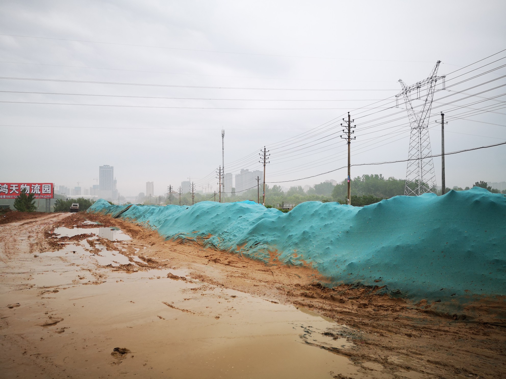 新鄭龍湖鎮一道路堆積黃土裸露進展已覆蓋防塵網