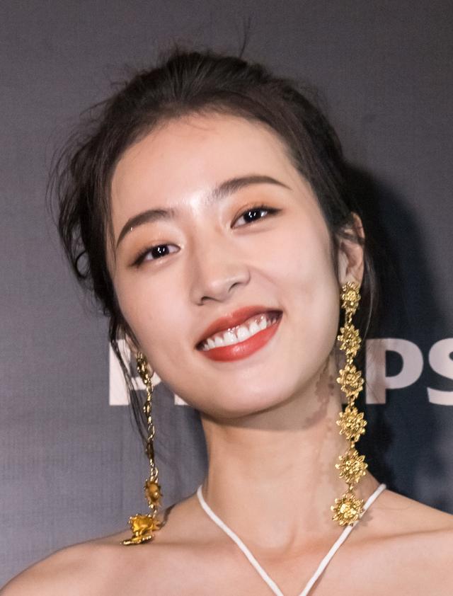 1/ 5 周雨彤的笑容真的很有魅力,妆容十分精致,金色的耳环显得十分