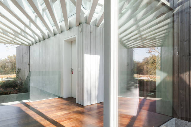 住宅创造了一个覆盖着平坦的透明屋顶和全尺寸窗户的空间