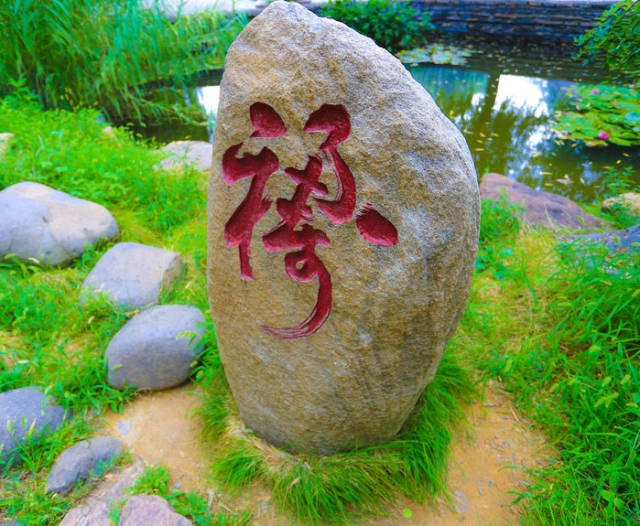石头上的红色字体是福字和寿字的合体字禄字,代表着福寿合一福寿双全