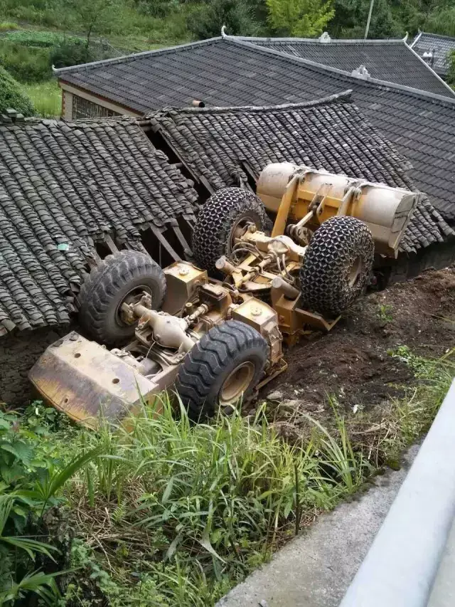咸丰坪坝营一辆工程车侧翻跌落到一屋顶上.