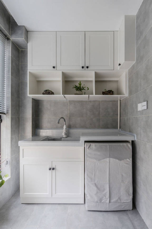 洗衣机放在阳台,还装了吊柜,放几盆绿植,档次是不是上去啦.